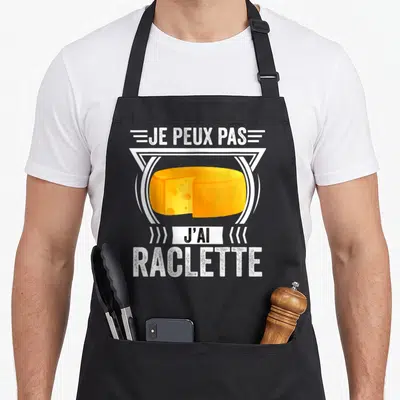 Tablier de cuisine noir avec illustration de fromage raclette et texte je peux pas j'ai raclette en blanc.