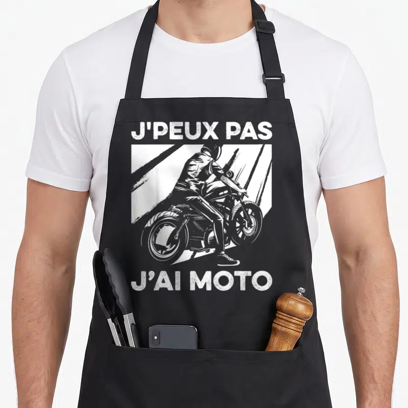 Tablier de cuisine noir avec illustration d'un motard et le texte J'PEUX PAS J'AI MOTO imprimé en blanc.