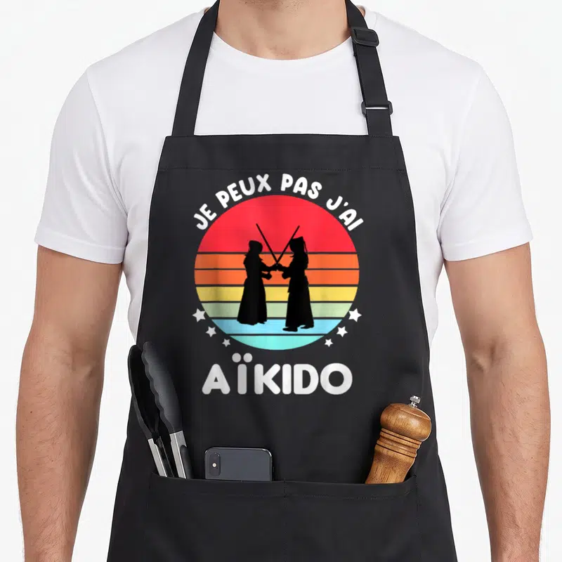 Tablier de cuisine noir avec motif rétro Je peux pas j'ai Aïkido et silhouettes de pratiquants.