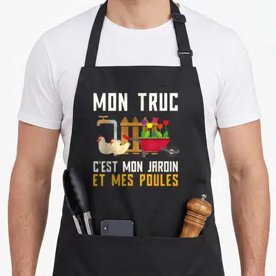 Tablier de cuisine noir avec une brouette rouge, des tulipes, deux poules blanches et une clôture en bois.