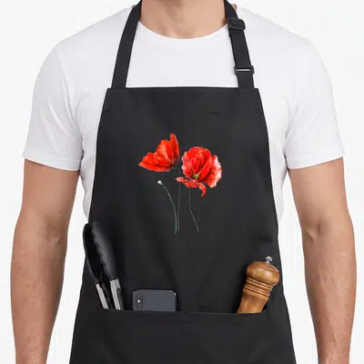 Tablier de cuisine noir avec deux coquelicots rouges peints à l'aquarelle et une tige verte sur fond uni.