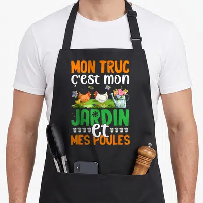 Tablier de cuisine noir avec inscription colorée sur le jardinage et des poules autour d'un arrosoir.