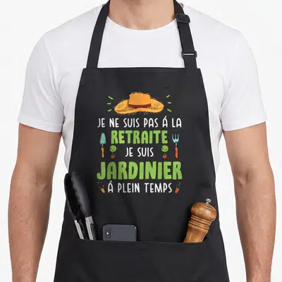 Tablier de cuisine noir avec inscription Je ne suis pas à la retraite je suis jardinier à plein temps et illustrations d'outils de jardinage.