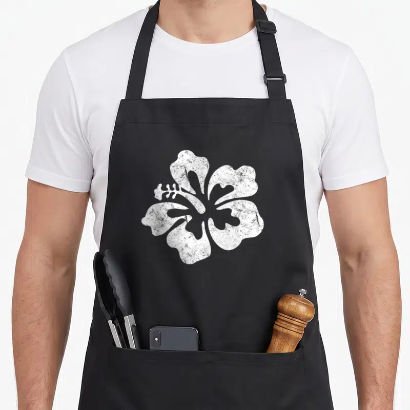 Tablier de cuisine noir avec une grande fleur d'hibiscus blanche au centre, style texture granuleuse.