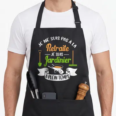 Tablier de cuisine noir avec inscription Je ne suis pas à la retraite je suis jardinier à plein temps entouré d'une brouette et d'outils.
