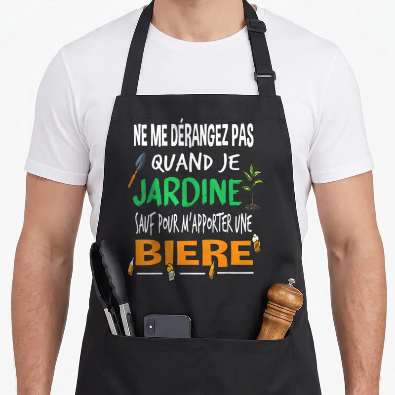 Tablier de cuisine noir avec l'inscription Ne me dérangez pas quand je jardine sauf pour m'apporter une bière accompagnée d'une pelle et de verres.