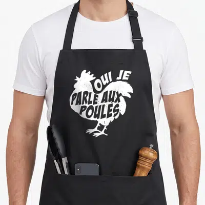 Tablier de cuisine noir avec une illustration blanche d'une poule formée par le texte Oui je parle aux poules.