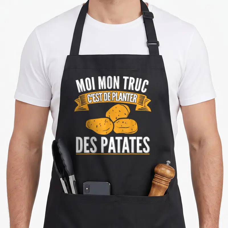 Tablier de cuisine noir avec inscription blanche et illustration de trois patates jaunes sur banderole orange.