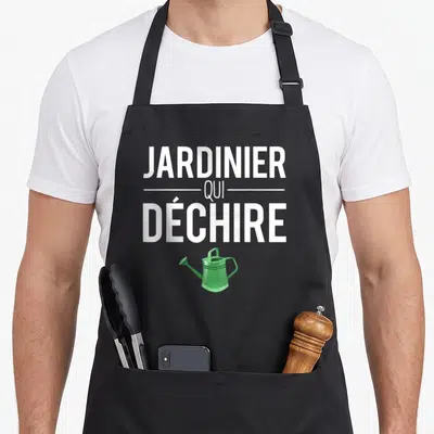 Tablier de cuisine noir avec l'inscription JARDINIER QUI DÉCHIRE et un petit arrosoir vert en dessous.