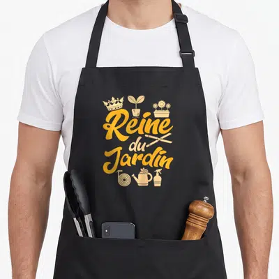 Tablier de cuisine noir avec typographie Reine du Jardin et icônes de jardinage dorées.