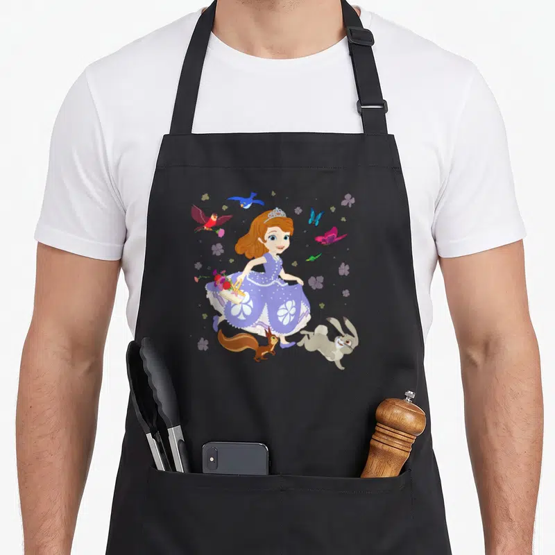 Tablier de cuisine noir avec illustration de Sofia la première et des animaux dans un jardin floral.