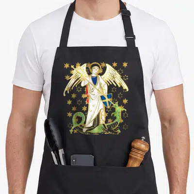 Tablier de cuisine noir avec une illustration colorée de Saint Michel l'Archange tenant une lance et un bouclier au-dessus d'un dragon vert.