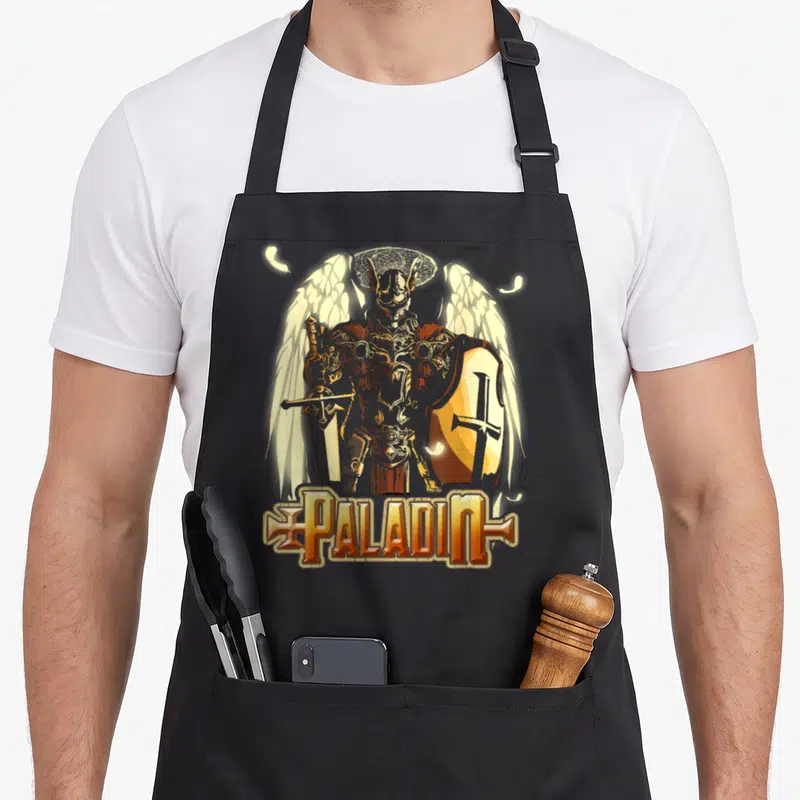 Tablier de cuisine noir avec illustration d'un Paladin aux ailes blanches, bouclier, épée et le mot PALADIN en typographie fantasy dorée.