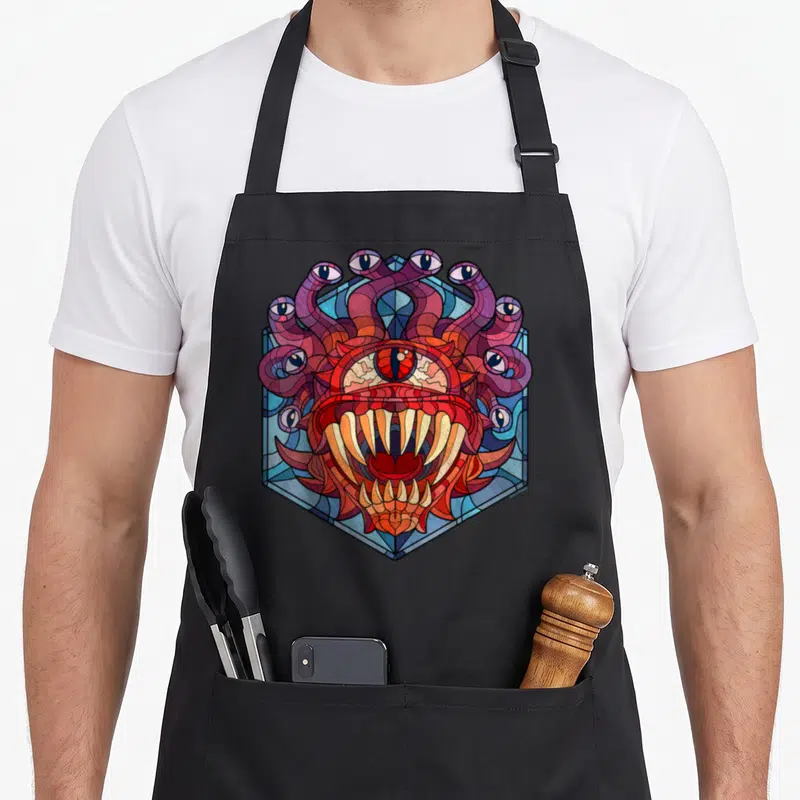 Tablier de cuisine noir avec illustration Beholder vitrail aux couleurs vives et détails oculaires complexes.