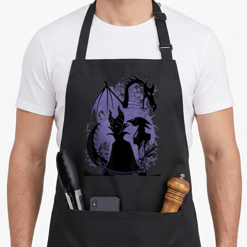 Tablier de cuisine noir avec silhouette Maleficent et dragon violet sur fond texturé.