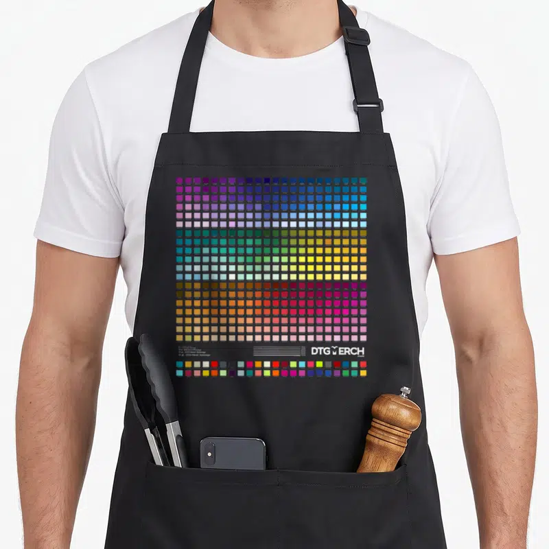 Tablier de cuisine noir avec une grille de carrés colorés représentant une palette de couleurs technique et des nuances variées.