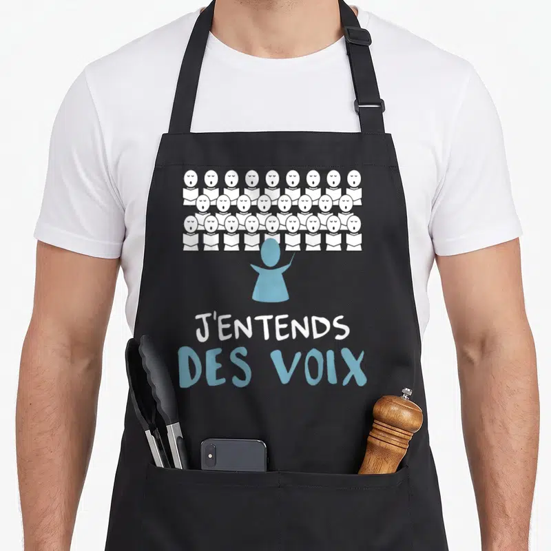 Tablier de cuisine noir avec illustration d'un chœur et le texte J'entends des voix en blanc et bleu.