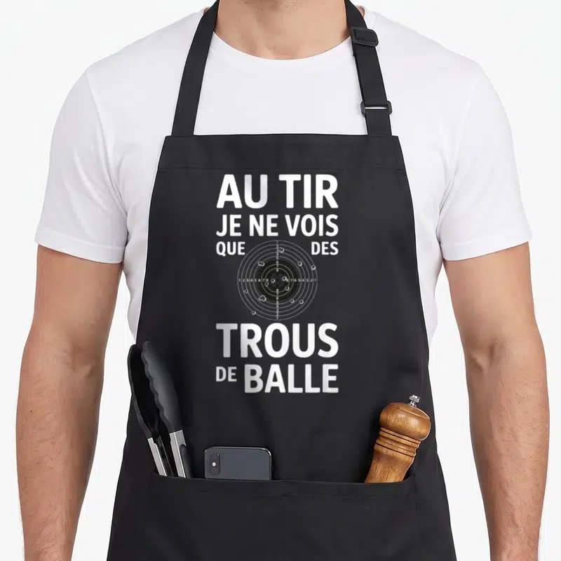 Tablier de cuisine noir avec cible de tir et inscription blanche humoristique sur la précision.