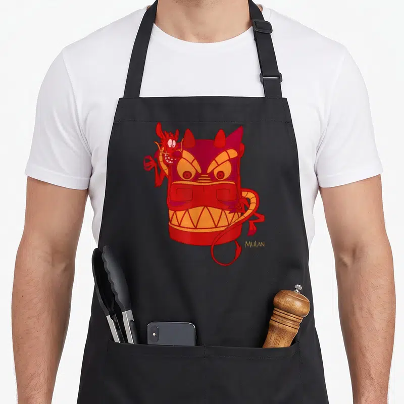 Tablier de cuisine noir avec illustration de Mushu et un masque de dragon rouge stylisé signé Mulan