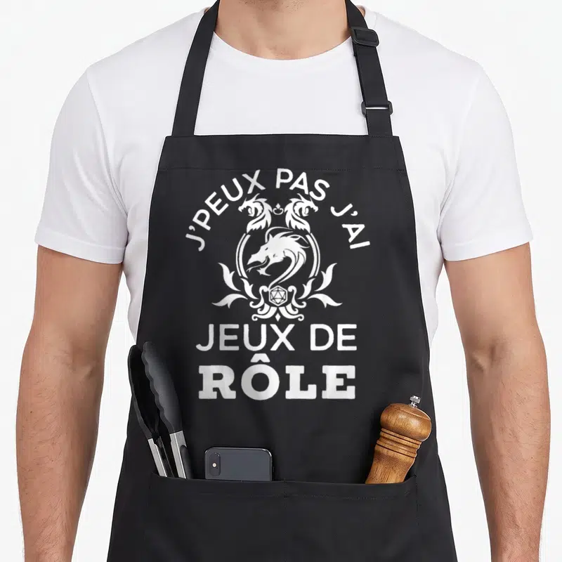 Tablier de cuisine noir avec inscription blanche J'peux pas j'ai jeux de rôle et motif de dragon stylisé.