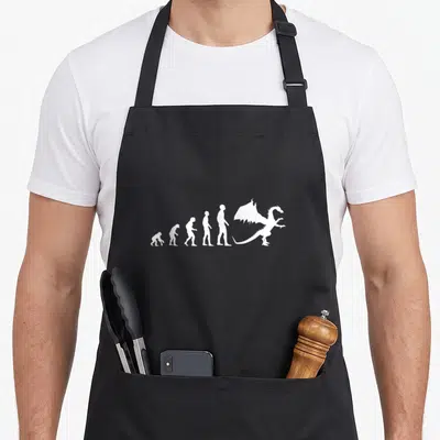Tablier de cuisine noir avec une illustration blanche représentant l'évolution humaine se terminant par un dragon ailé.