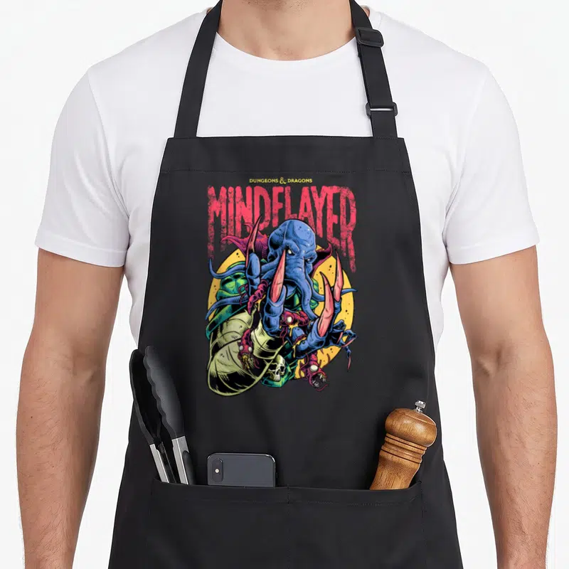 Tablier de cuisine noir avec une illustration colorée d'un Mindflayer aux tentacules bleus et griffes roses sur fond jaune.