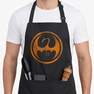 Tablier de cuisine noir avec logo dragon orange tonal en forme de cercle stylisé au centre.