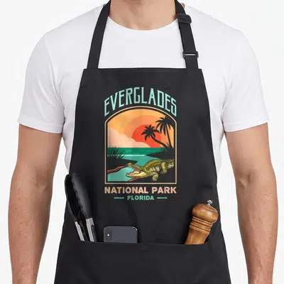 Tablier de cuisine noir avec illustration d'un crocodile aux Everglades et texte Everglades National Park Florida en style vintage.