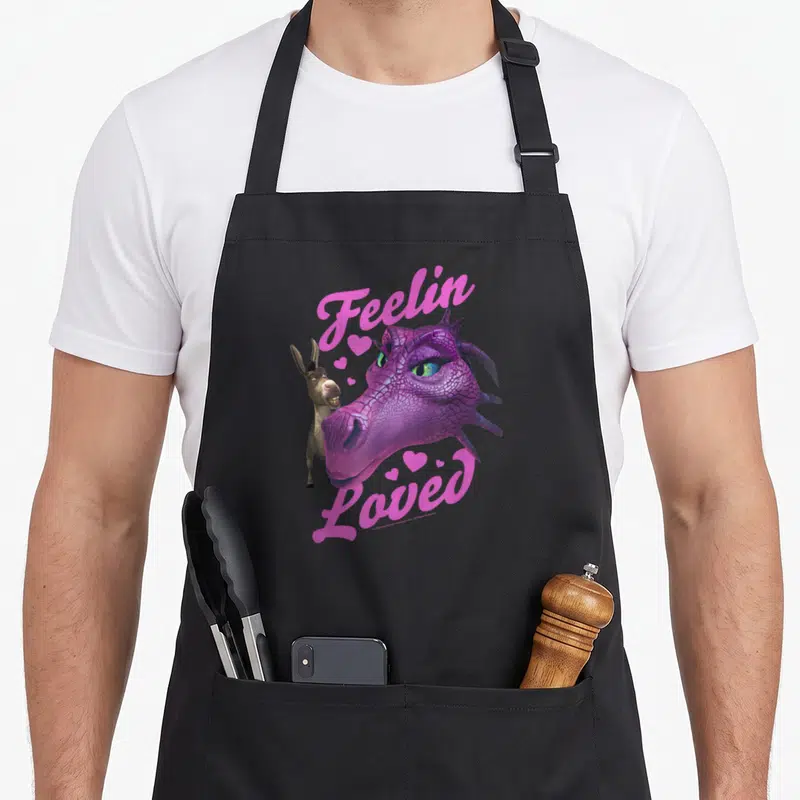 Tablier de cuisine noir avec Donkey, une dragonne rose et l'inscription Feelin Loved en lettres roses.