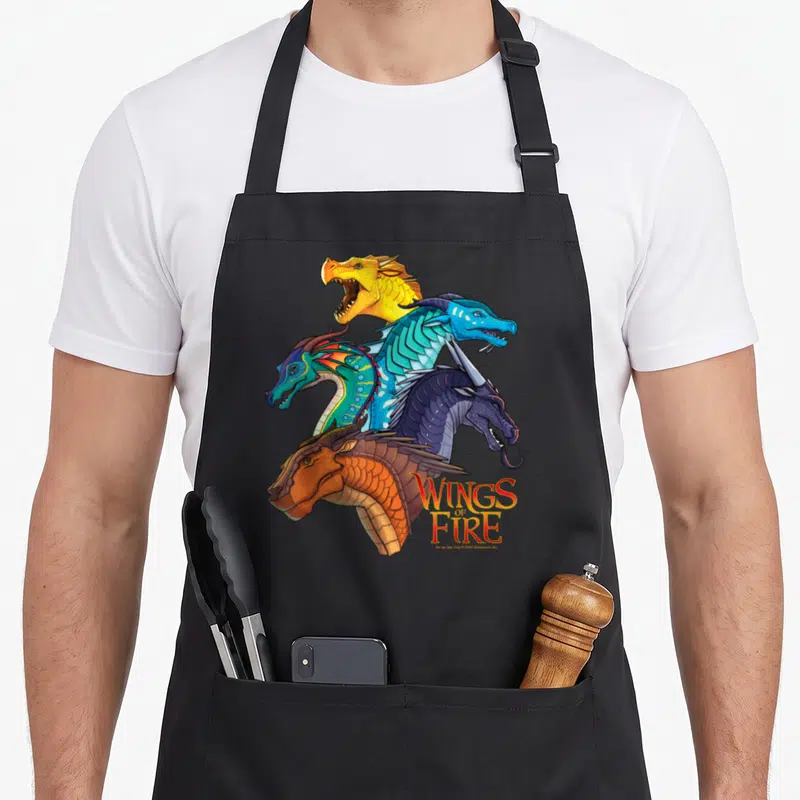 Tablier de cuisine noir avec cinq têtes de dragons colorés et le logo Wings of Fire imprimé au centre.