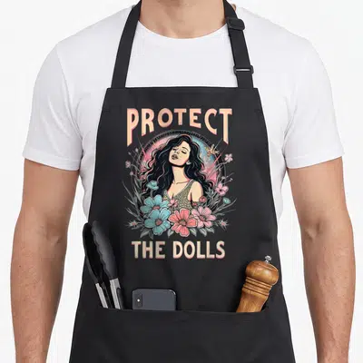 Tablier de cuisine noir avec une femme aux cheveux longs entourée de fleurs bleues et roses sous les mots Protect The Dolls.
