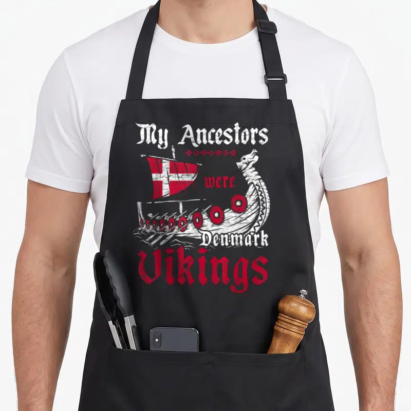Tablier de cuisine noir avec illustration de drakkar viking, drapeau danois et texte My Ancestors Were Denmark Vikings en rouge et blanc.