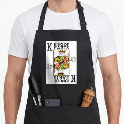 Tablier de cuisine noir avec illustration roi des cartes King of Farts et nuages de gaz humoristiques.
