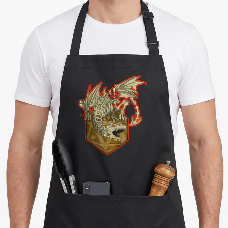 Tablier de cuisine noir avec un dragon squelette tenant une dice rouge au-dessus d'une dice dorée géante.