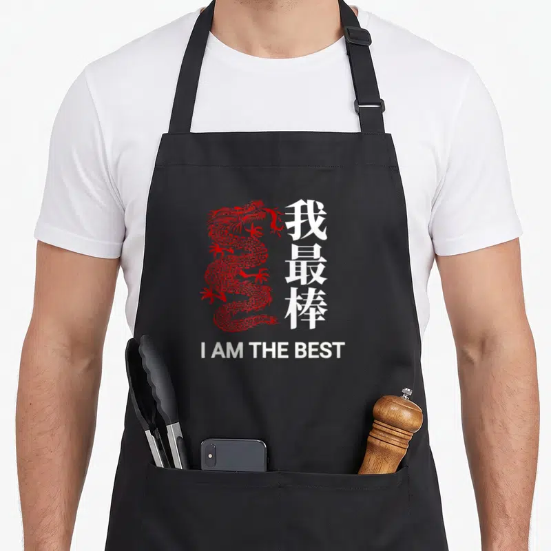 Tablier de cuisine noir avec un dragon rouge stylisé et le texte blanc I AM THE BEST en bas.