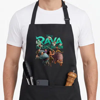 Tablier de cuisine noir avec illustration colorée de Raya, Boun et du titre Disney Raya et le dernier dragon.
