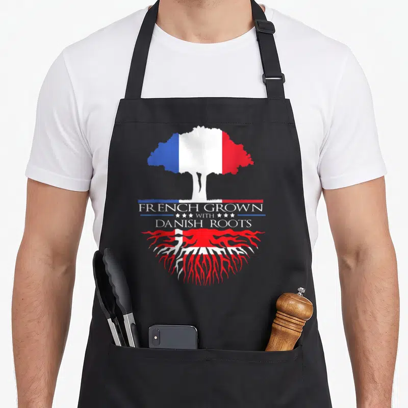 Tablier de cuisine noir avec un arbre aux drapeaux français et danois et le texte French Grown with Danish Roots.