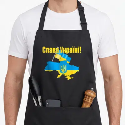 Tablier de cuisine noir avec une carte de l'Ukraine, un drapeau et l'inscription en lettres jaunes.