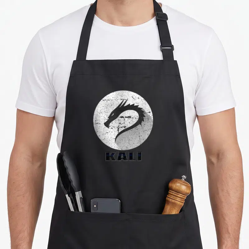 Tablier de cuisine noir avec logo tête de dragon Kali et texte texturé en bas du motif circulaire.