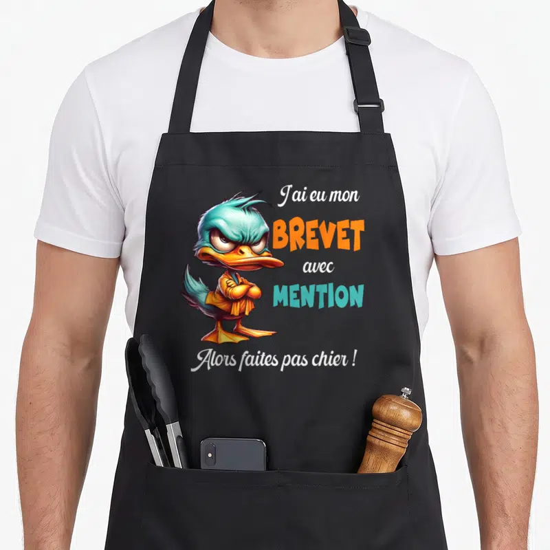 Tablier de cuisine noir avec un canard aux bras croisés et le texte Brevet avec mention Faites pas chier