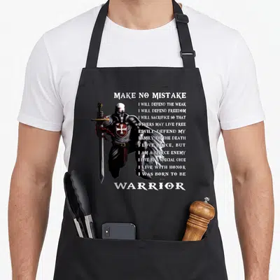 Tablier de cuisine noir avec illustration d'un Templier tenant une épée et texte blanc sur fond gris uni.