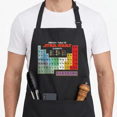 Tablier de cuisine noir avec un tableau périodique des éléments Star Wars coloré et détaillé.