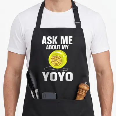 Tablier de cuisine noir avec illustration jaune d'un yo-yo et texte blanc Ask Me About My YoYo.