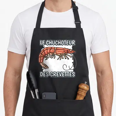 Tablier de cuisine noir avec illustration colorée d'une crevette rose et texte blanc en lettres capitales.