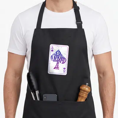 Tablier de cuisine noir avec une illustration de carte à jouer blanche aux motifs violets et bleus.