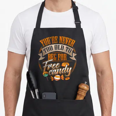 Tablier de cuisine noir avec inscription sur la mendicité de bonbons gratuits et illustrations de sucreries colorées.