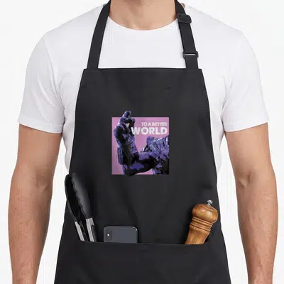 Tablier de cuisine noir avec illustration d'une main gantée violet foncé et texte TO A BETTER WORLD sur fond rose.