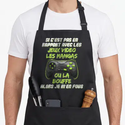 Tablier de cuisine noir orné d'une manette de console verte et d'un texte humoristique sur les jeux vidéo et la bouffe