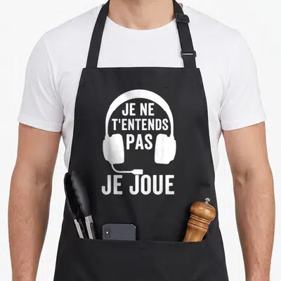 Tablier de cuisine noir avec illustration blanche d'un casque audio et texte humoristique sur fond uni