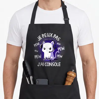 Tablier de cuisine noir avec un chat blanc en train de jouer à la console sous un halo violet.